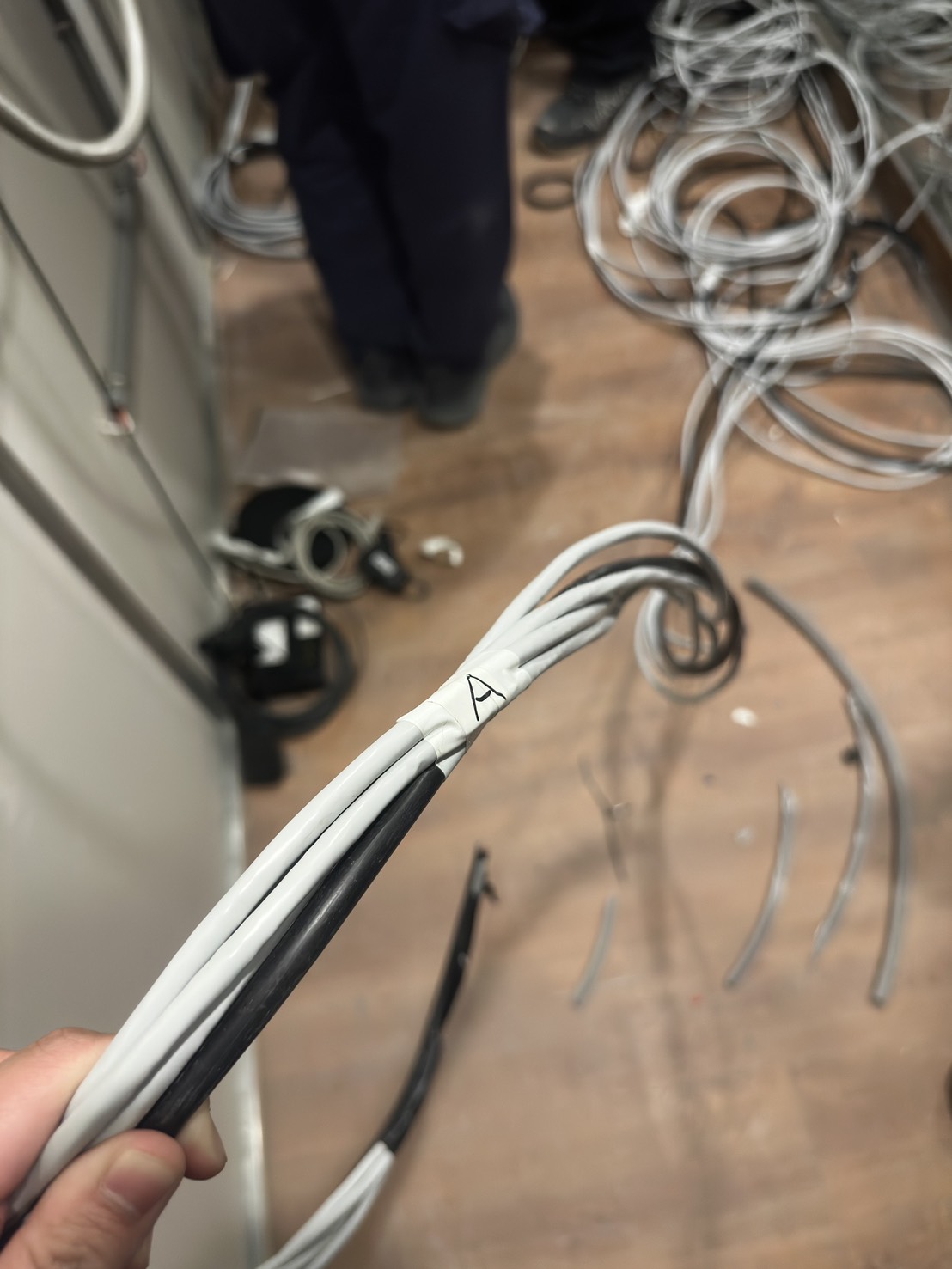 佳實工程人員手持標示「A」的分類線路束，弱電施工現場線路整理實錄